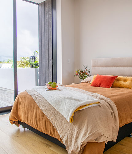 Bright coloured bed with a beige headboard